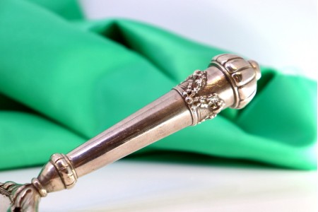 Apanha migalhas em prata com relevos florais e laços no cabo.